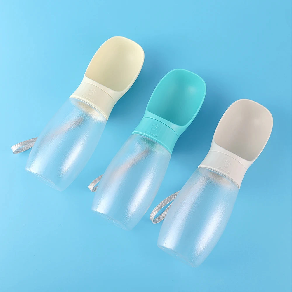 A set of clear silicone portable pet water bottles with integrated bowls in light blue and beige colors.
