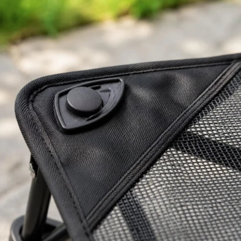 Close-up of a black foldable elevated pet cot with breathable mesh fabric.