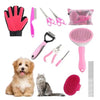 Eine Sammlung rosa und schwarzer Tierpflegewerkzeuge, darunter Nagelscherer, Bürsten und ein rosa Pflegehandschuh.