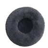A round, dark gray plush pet bed for dogs and cats.