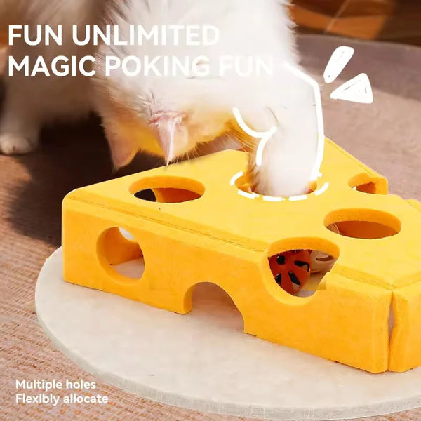 A white kitten is interacting with a yellow felt maze play box designed for magic poking fun.