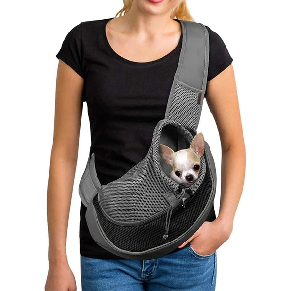 A woman is holding a gray hands-free pet sling carrier designed for small dogs and cats.