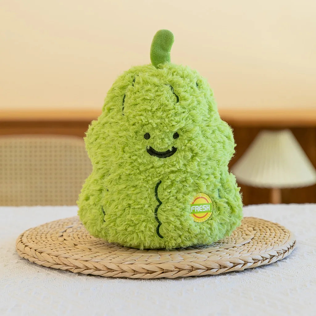 A bright green plush vegetable doll shaped like a broccoli sits on a woven mat.