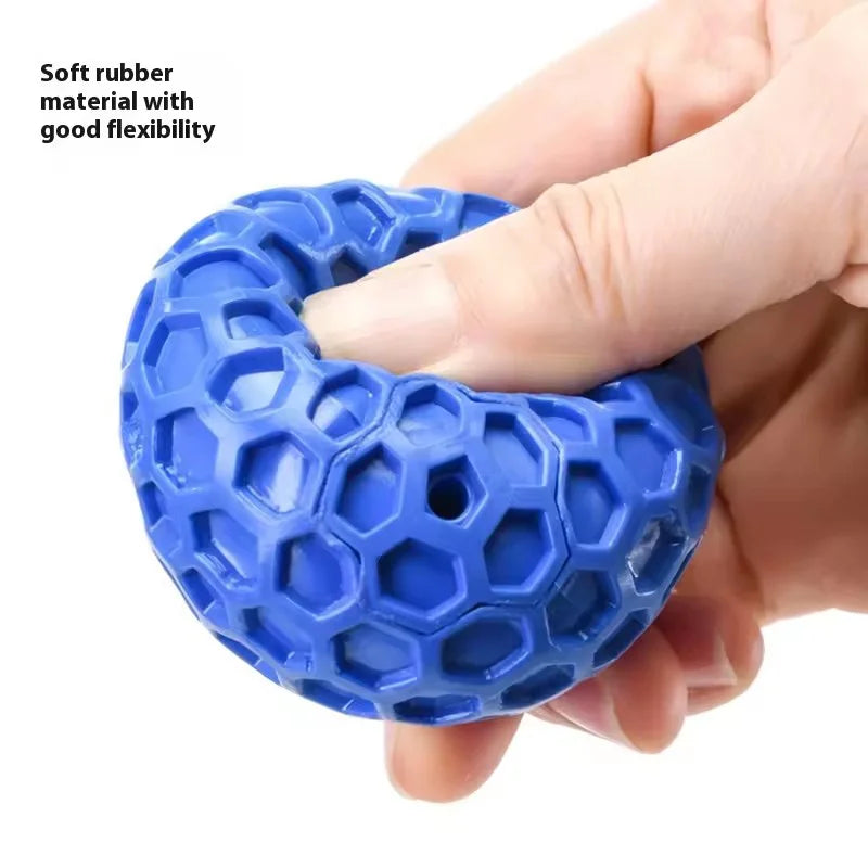A hand holds a bright blue honeycomb rubber squeaky dog toy ball with good flexibility.