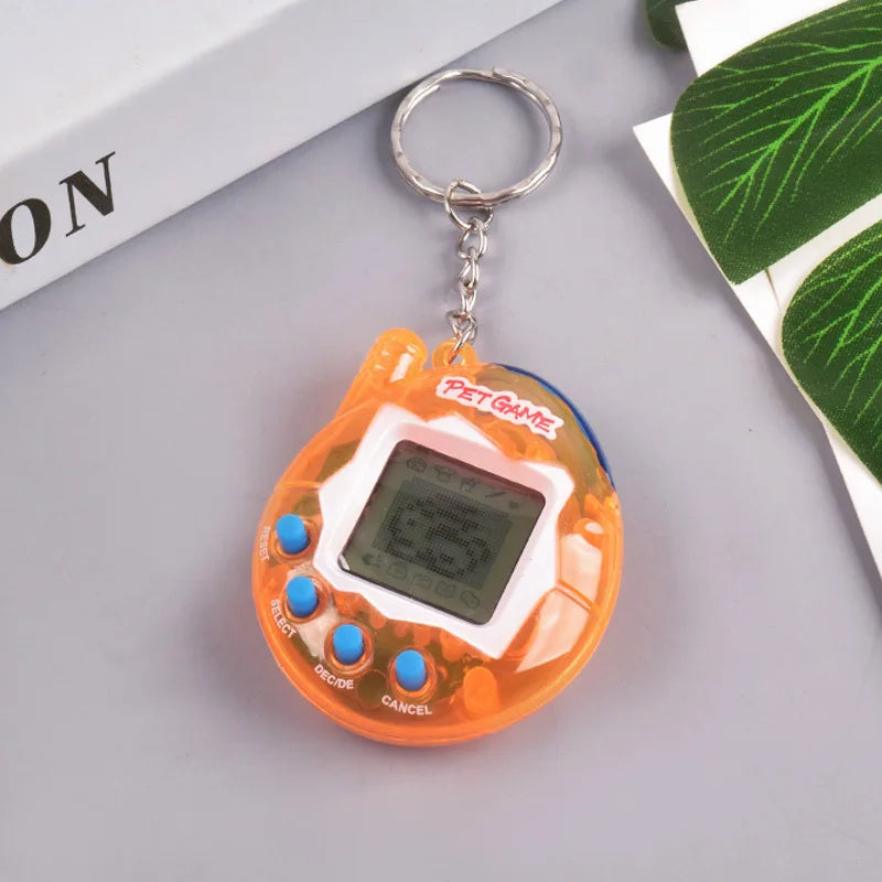 An orange transparent digital pet toy with a silver keyring and buttons resting on a gray surface.
