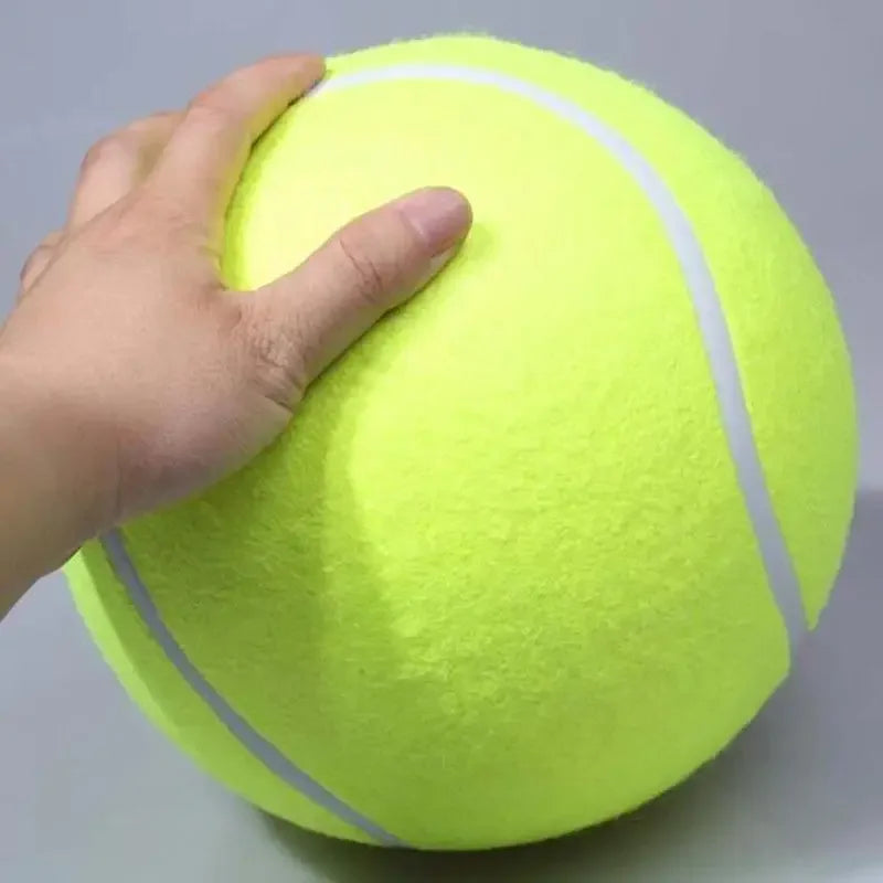 Eine Hand presst einen leuchtend neongelben aufblasbaren Hundtennisball.