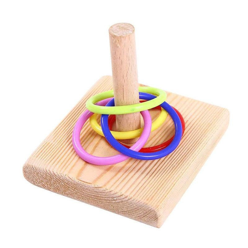 A wooden dowel holds a stack of colorful plastic rings, used as a bird toy.