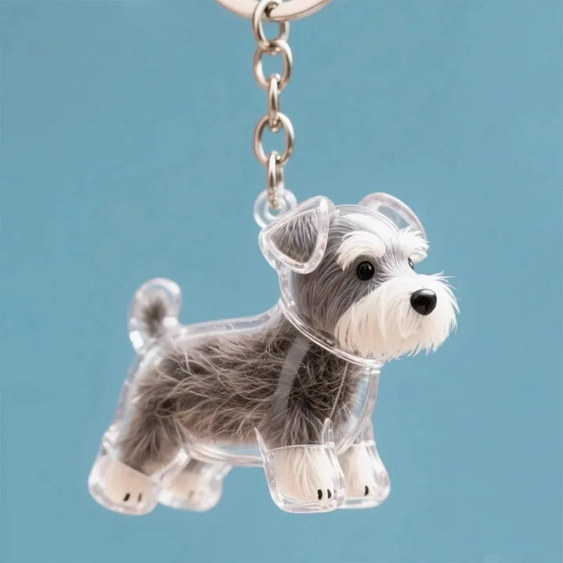 Figurine en plastique transparent d'un chien duveteux gris et blanc, accroché à une clé USB argentée.