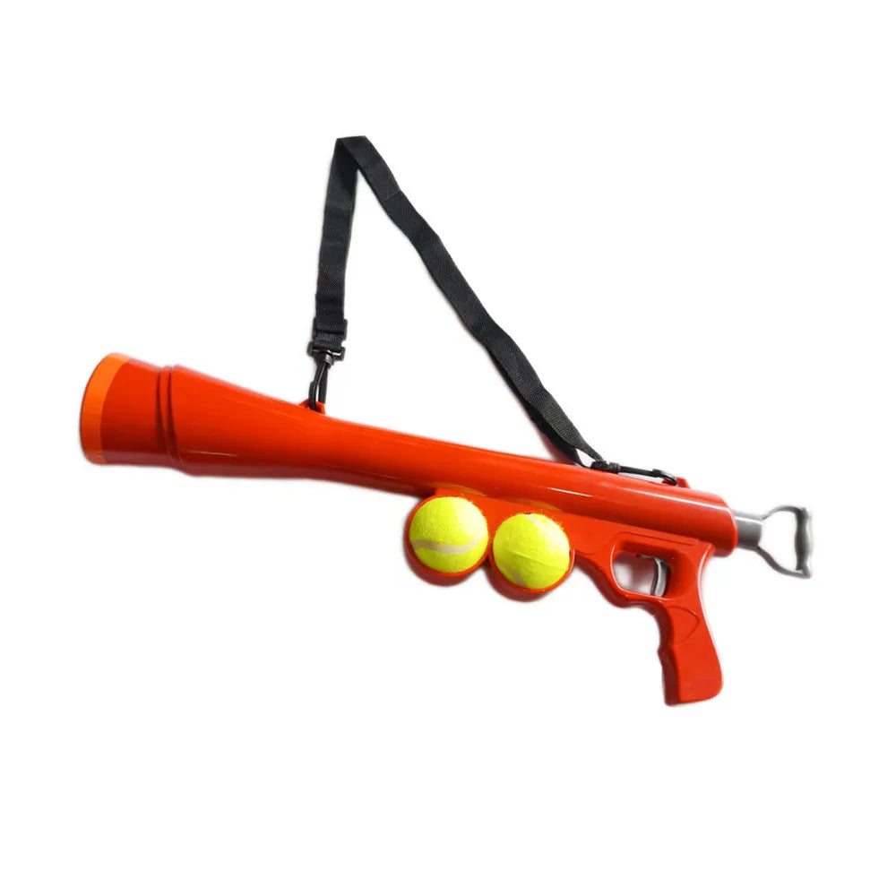 Orange interactive pet ball launcher for dogs with a black strap and two yellow balls.