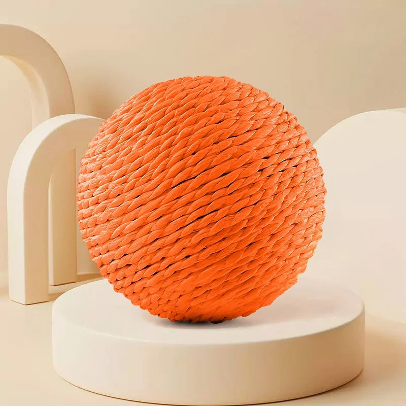 Orangefarbener geflochtener Sisal-Kratzball auf weißem runder Ständer.