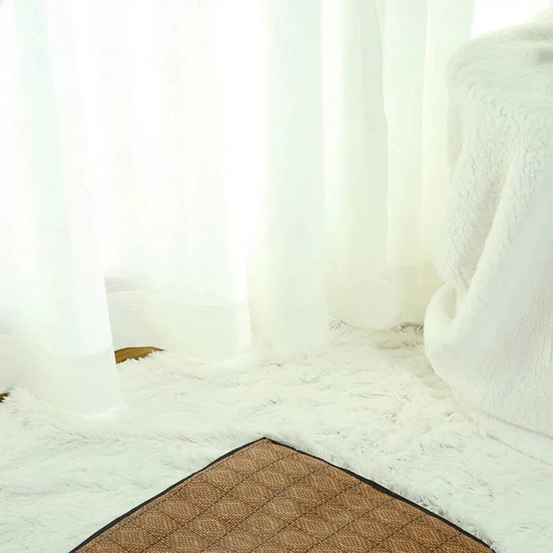 A fluffy white pet tent is displayed on a light-colored rug with a brown mat.