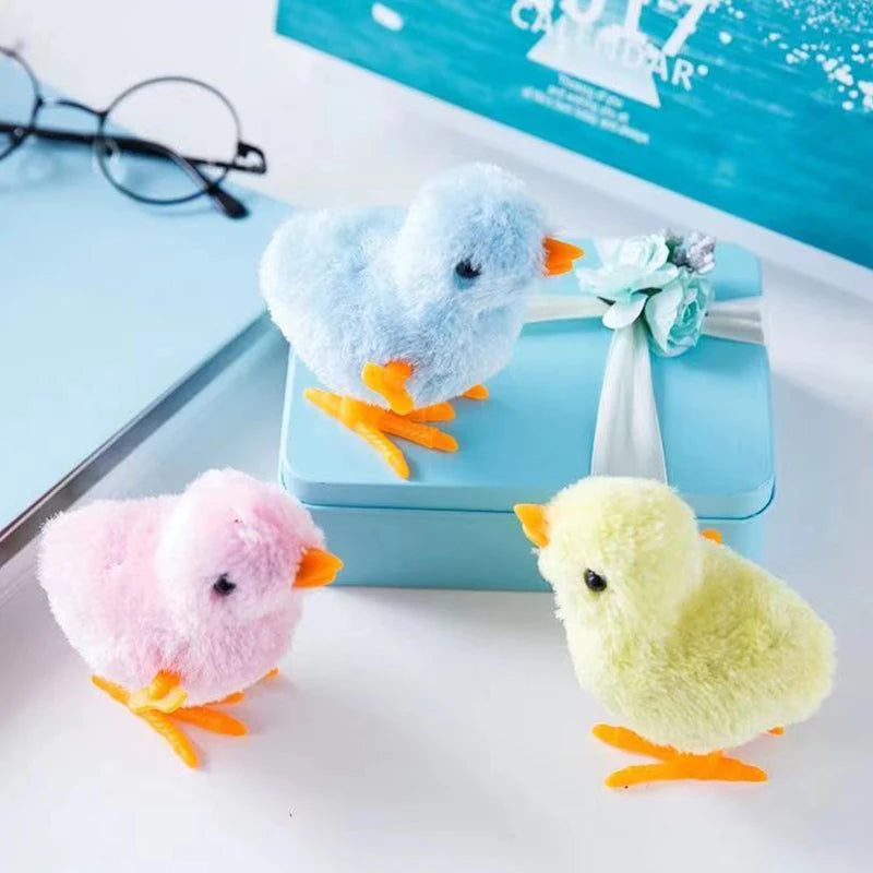 A fluffy blue and yellow wind-up plush chick toy sitting on a light blue box.