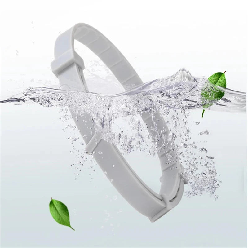 A white adjustable silicone pet collar is shown being splashed by water, with a green leaf floating nearby.