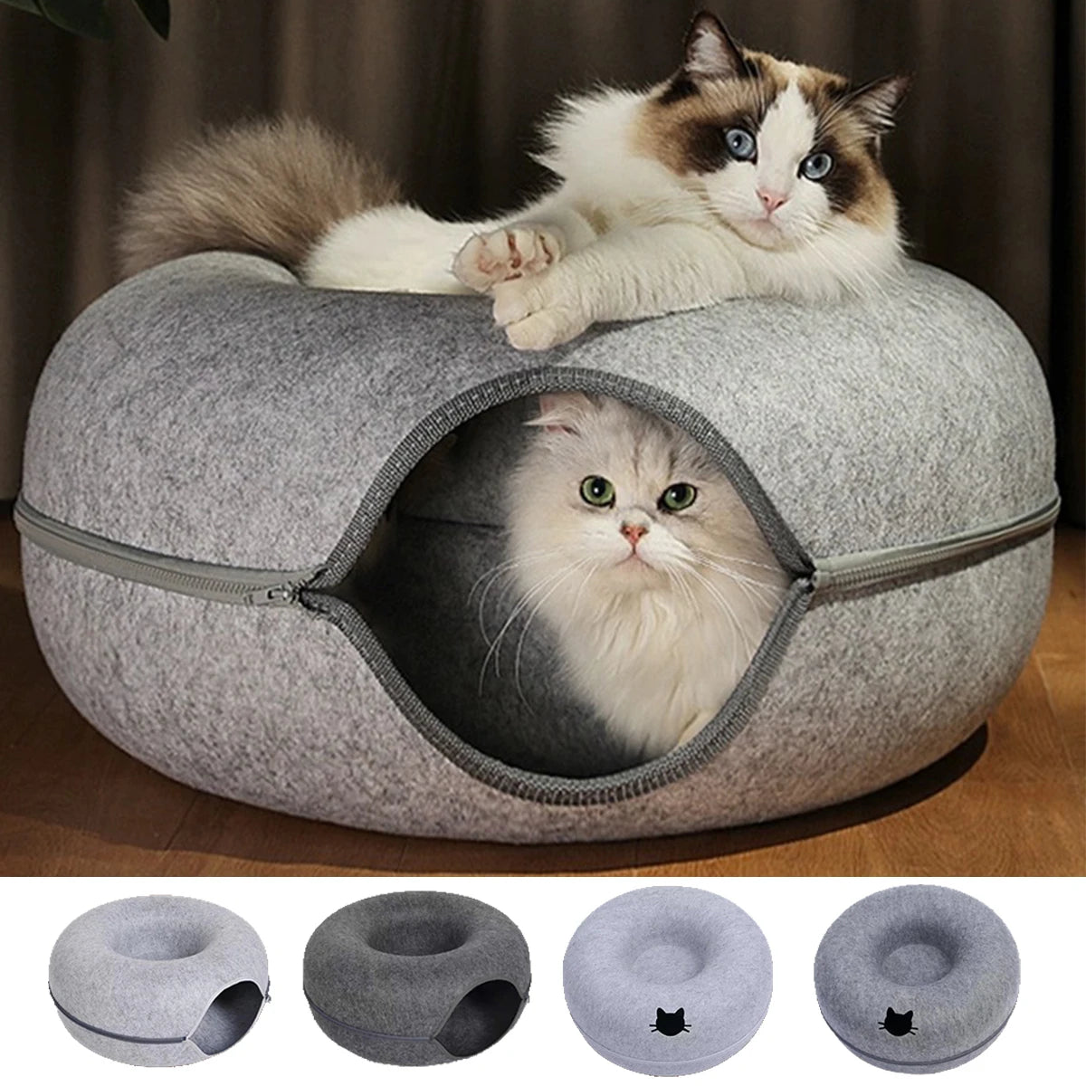 A fluffy tabby cat is resting inside a gray felt bed and tunnel nest, with another cat perched on top.