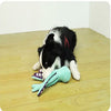 A black and white dog toy shaped like an octopus is lying on a wooden floor.