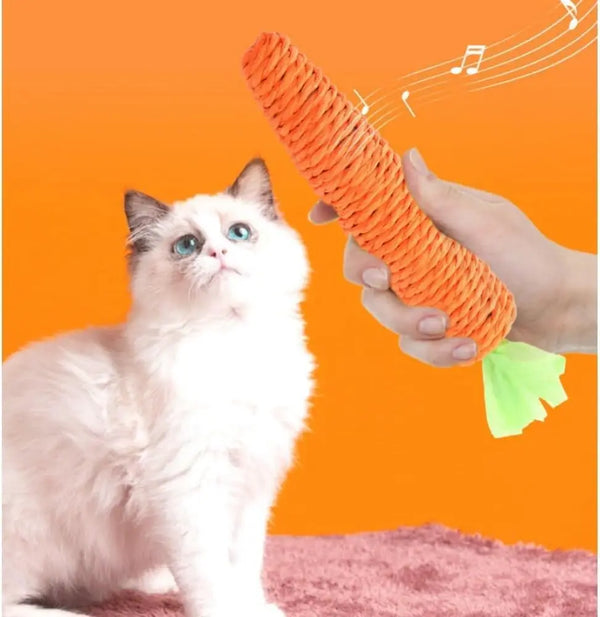 A hand is holding an orange carrot-shaped cat teething toy near a white and gray kitten.
