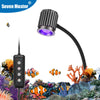 A black clip-on aquarium LED light fixture illuminates a vibrant underwater landscape with coral and marine plants.