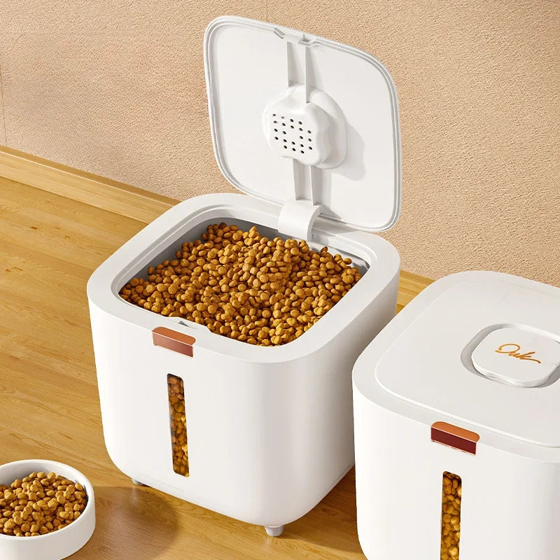 A white airtight pet food storage bucket with an open lid, showing dry kibble inside and a partial view of the container.