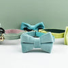 A collection of elegant velvet cat collars in mint green, blue, and lime yellow, featuring adjustable safety buckles and bowk