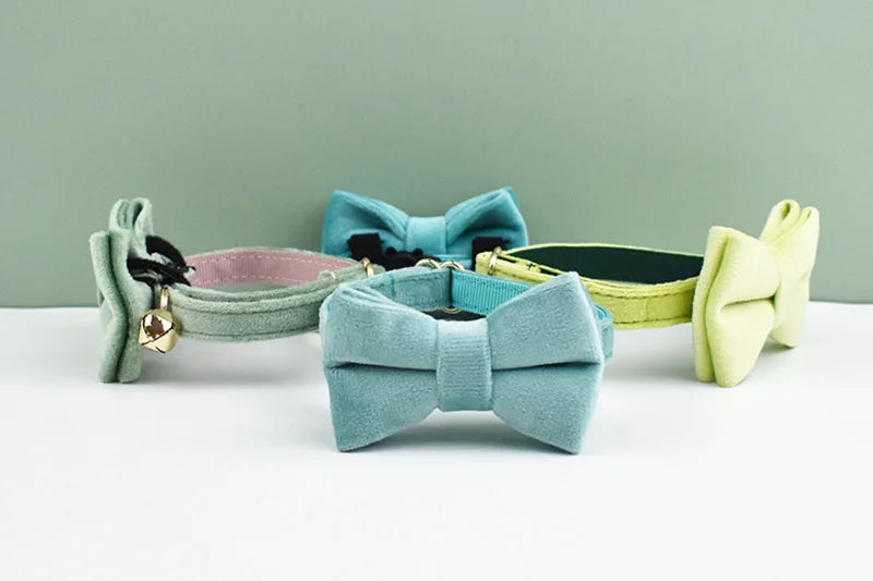 A collection of elegant velvet cat collars in mint green, blue, and lime yellow, featuring adjustable safety buckles and bowk