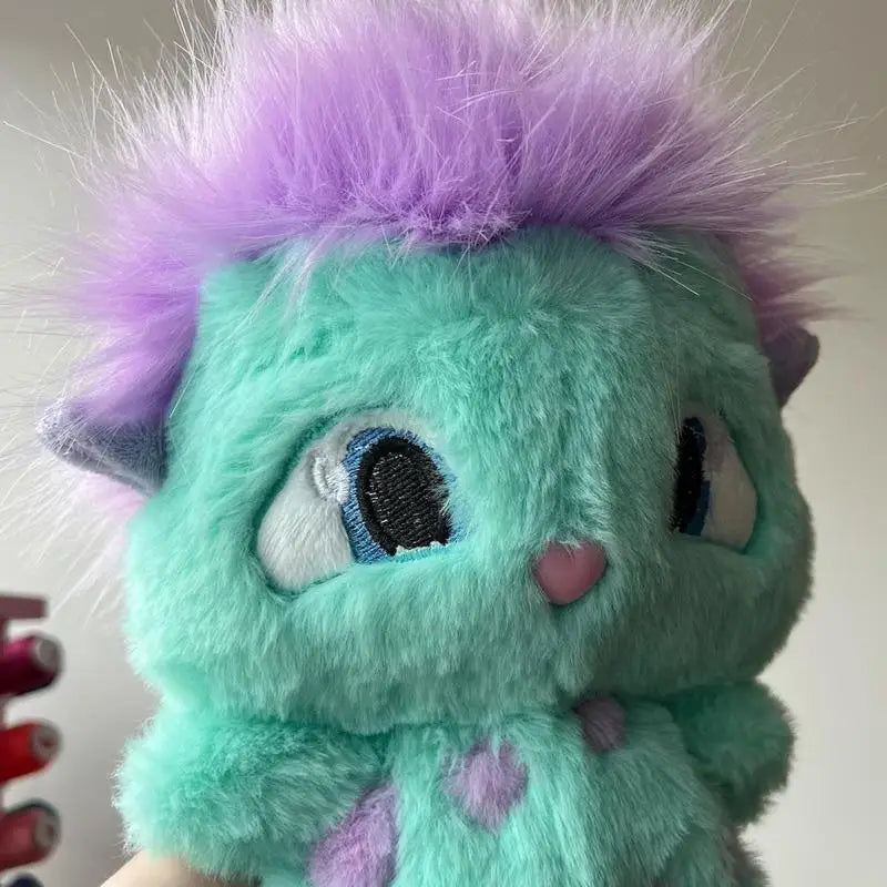 A soft teal and purple fluffy plush toy resembling an anime character face.