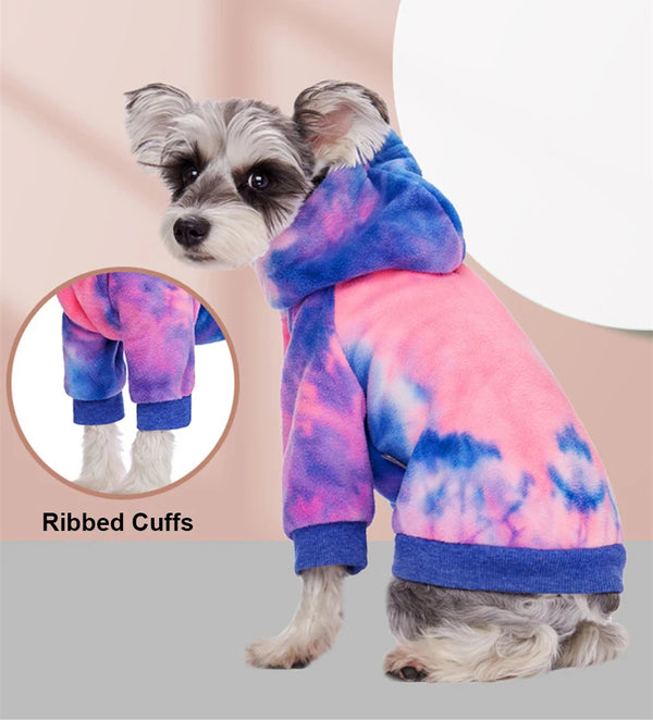 Ein kleiner Hund trägt einen tie-dye Fleece-Kapuzenpullover mit gerippten Ärmeln.