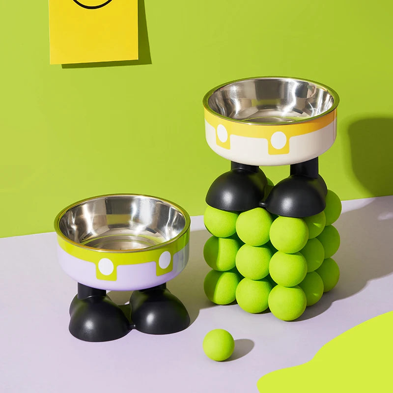 A set of elevated stainless steel pet bowls with lime green and black accents on a light purple surface.