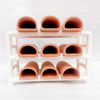 A white ceramic aquarium breeding cave with multiple orange-colored shrimp shelters.