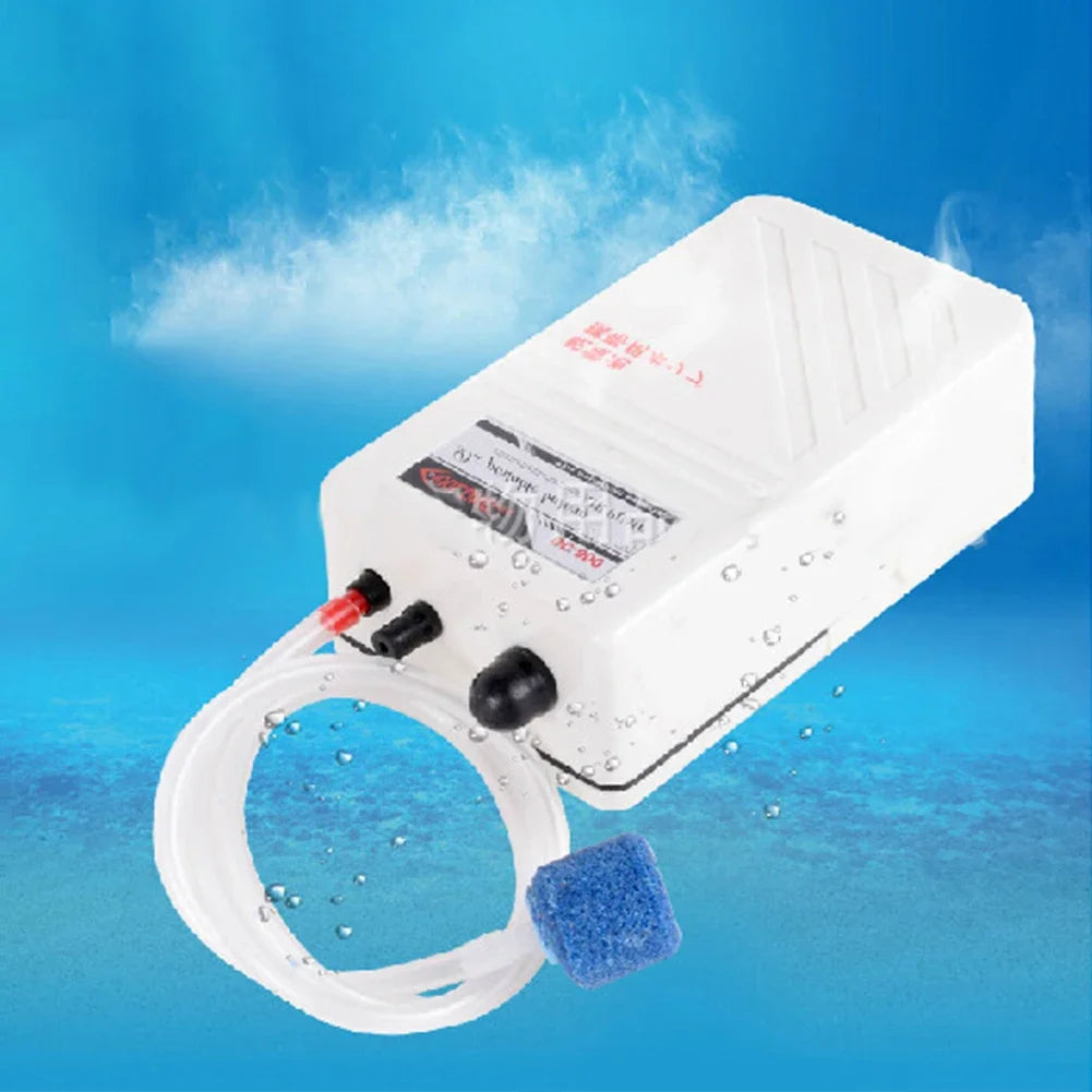 A white portable aquarium air pump with a clear tubing and a blue sponge visible against a blue background.
