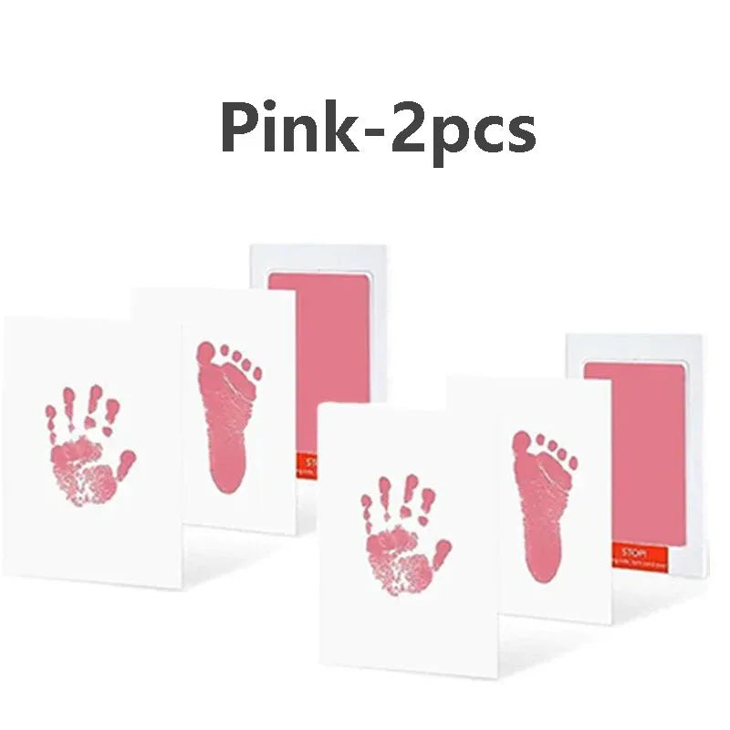 Deux cartes d'empreintes et de pas de main de bébé roses sur fond blanc.
