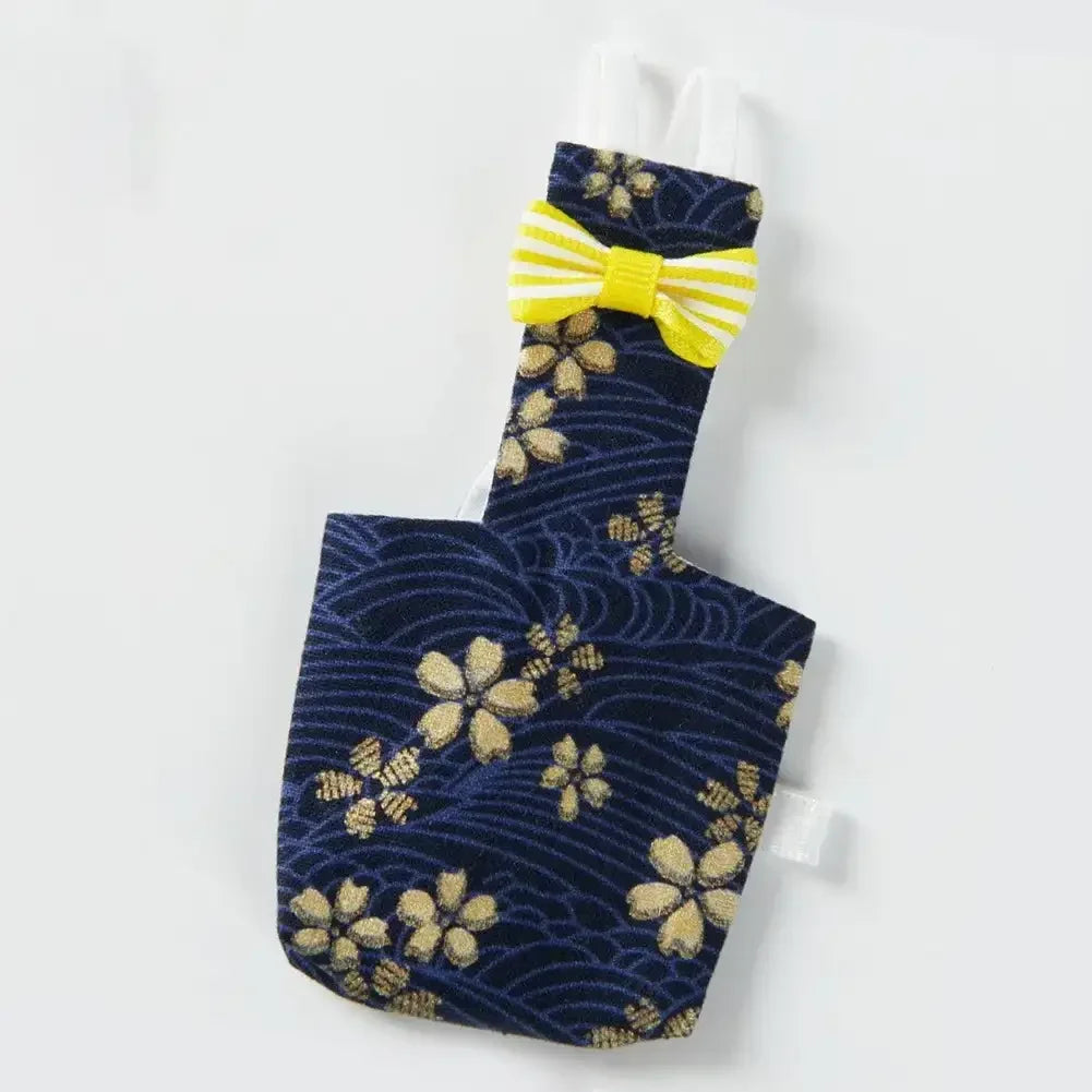 Navy blue floral patterned diaper flight suit with a yellow bow tie
