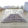 A stack of light blue and beige reversible plush pet sleeping mats for cats and small dogs.