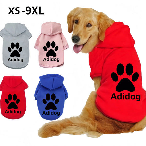 A golden retriever wearing a red hoodie with a paw print design, alongside various colored Adidog dog hoodies.