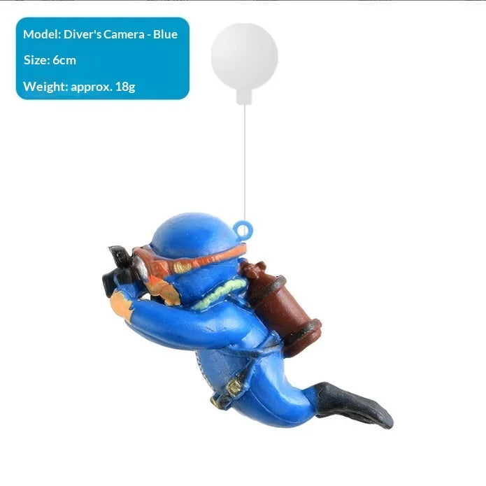 A blue diver ornament with an orange mask is suspended by a thin wire.