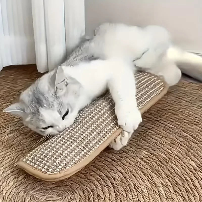 A white cat is lying on a sisal mat toy on a brown carpet.