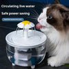 A cat is drinking water from a clear, automatic pet water fountain with a visible filter and pump.