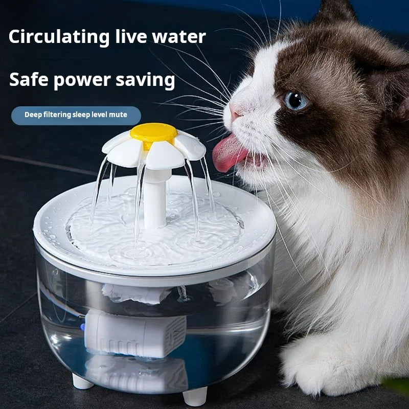 A cat is drinking water from a clear, automatic pet water fountain with a visible filter and pump.