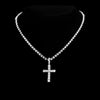 A close-up of a dainty diamond Cuban link necklace set with a cross pendant displayed against a black background.