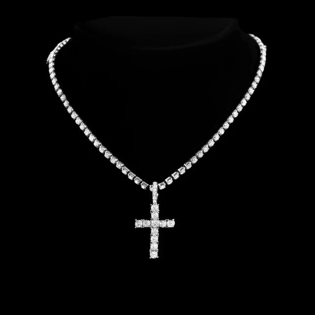 A close-up of a dainty diamond Cuban link necklace set with a cross pendant displayed against a black background.