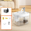 A clear glass pet drinking fountain with a metal spout is shown on a light-colored surface.
