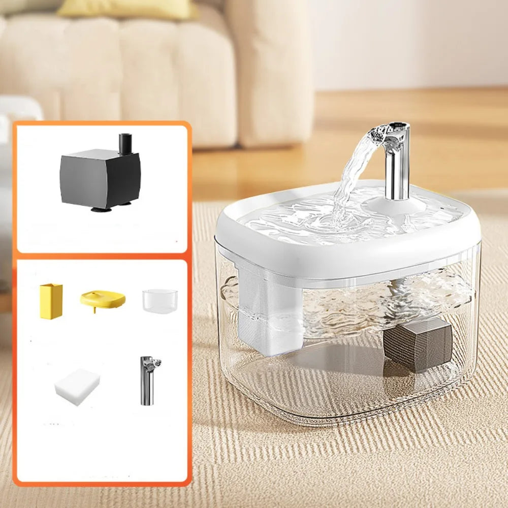 A clear glass pet drinking fountain with a metal spout is shown on a light-colored surface.