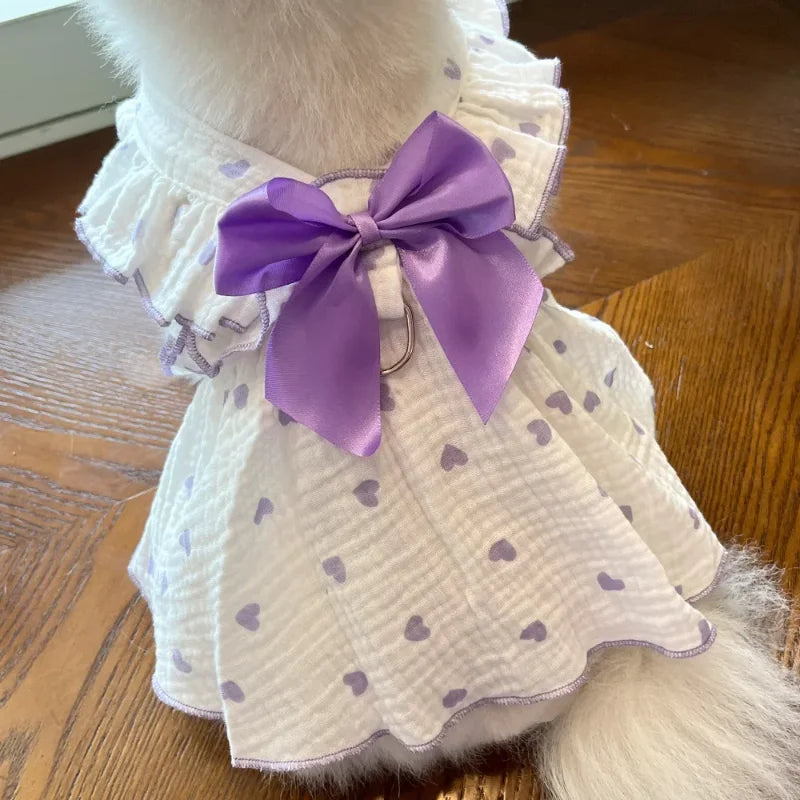 A white dog dress with a purple bow and heart print fabric for a chihuahua puppy.