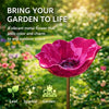 A vibrant magenta flower-shaped outdoor bird bath with a gold stand, featuring leaf, sparkle, and garden icons.