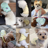 A collection of fluffy dogs wearing floral embroidered summer vests in various colors and styles.