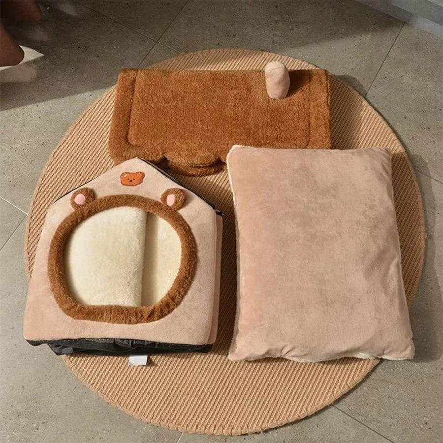 A beige foldable pet house for cats and small dogs with a brown fluffy trim resting on a round mat.