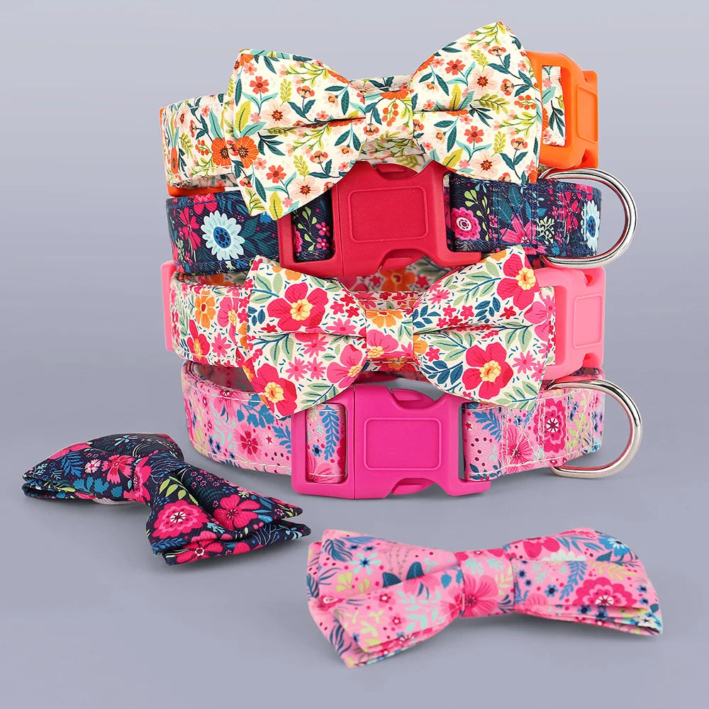 A stack of floral nylon dog collars featuring adjustable bowknots in pink, orange, and multicolored patterns.