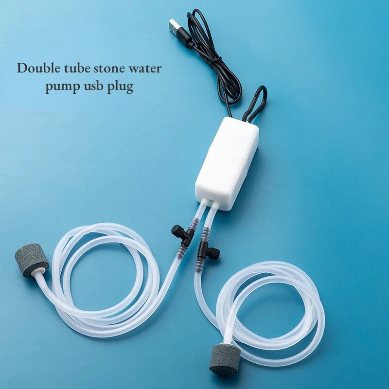 مضخة مياه حجرية مزدوجة الأنابيب مع قابس USB وأنبوب شفاف على خلفية زرقاء.