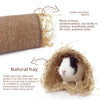A small white and black pet is nestled inside a natural hay tunnel hideout made of straw and linen fabrics.