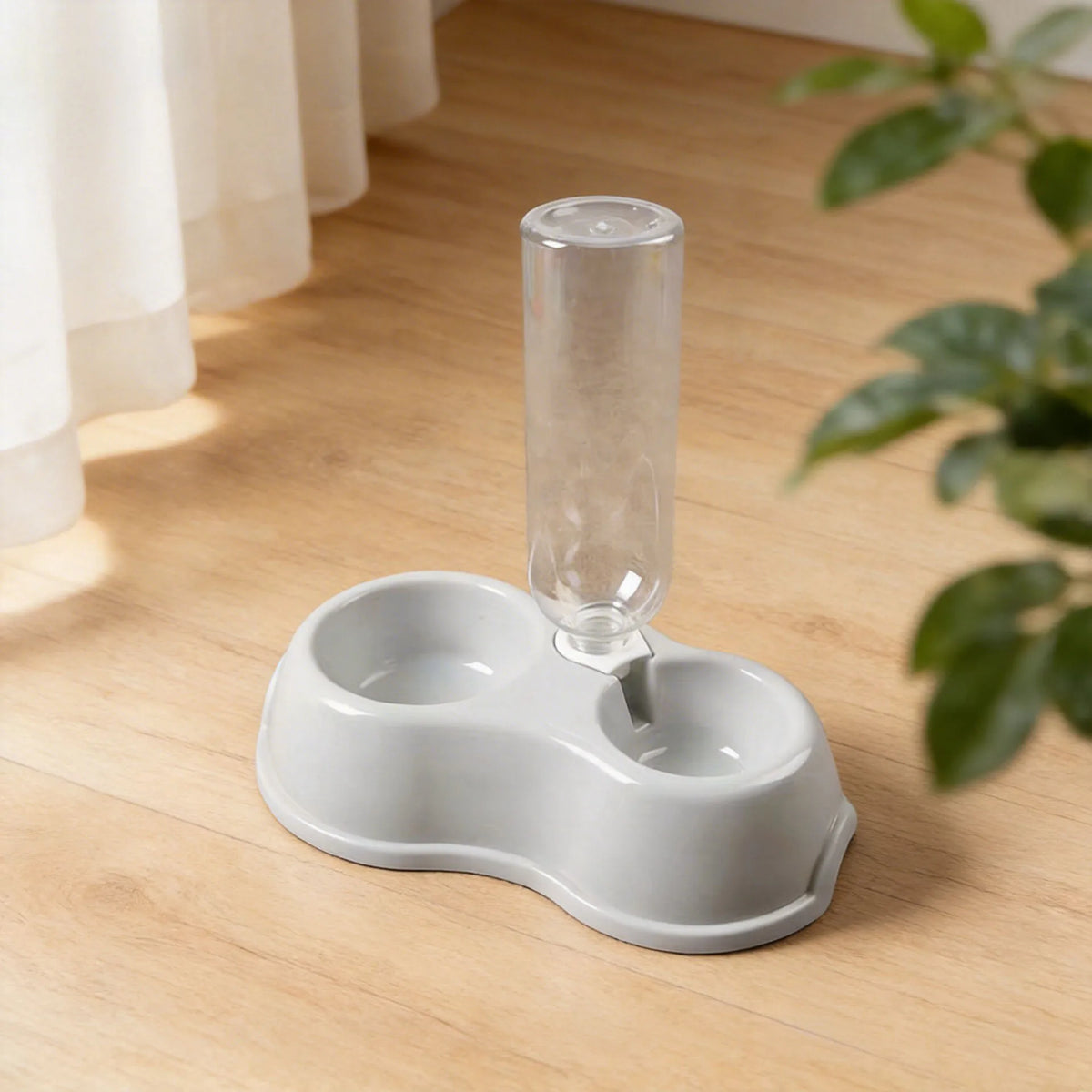 A white dual-bowl feeder for cats and dogs with a clear water dispenser sitting on a wooden floor.