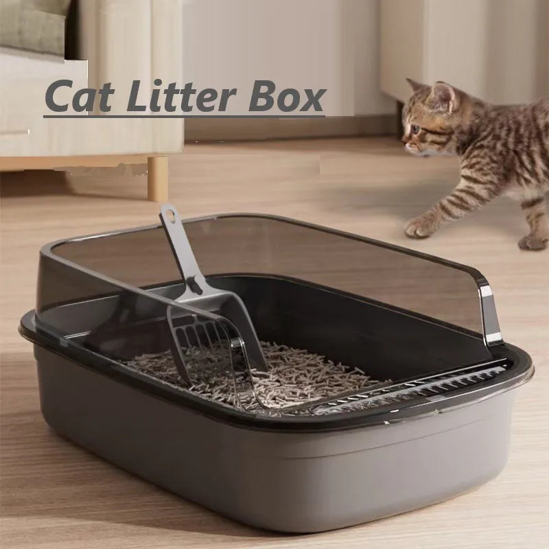 A gray semi-enclosed splashproof cat litter box with a metal scoop is shown on a wooden floor.